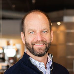 A headshot of Dewey's Pizza founder, Dewey