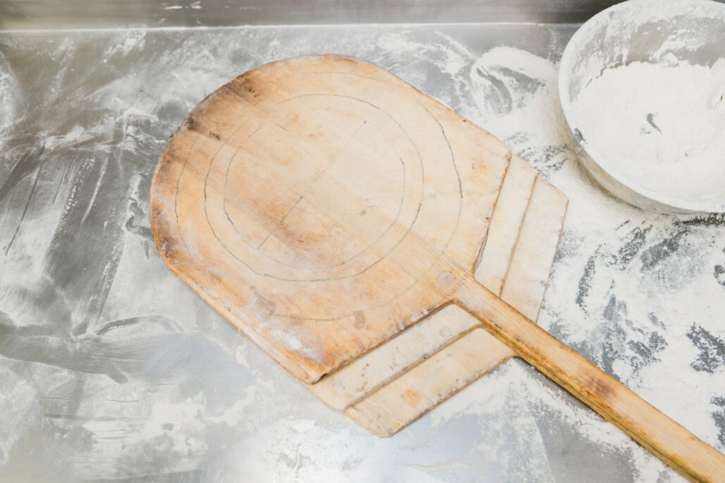 a pizza peel laying on a floured surface
