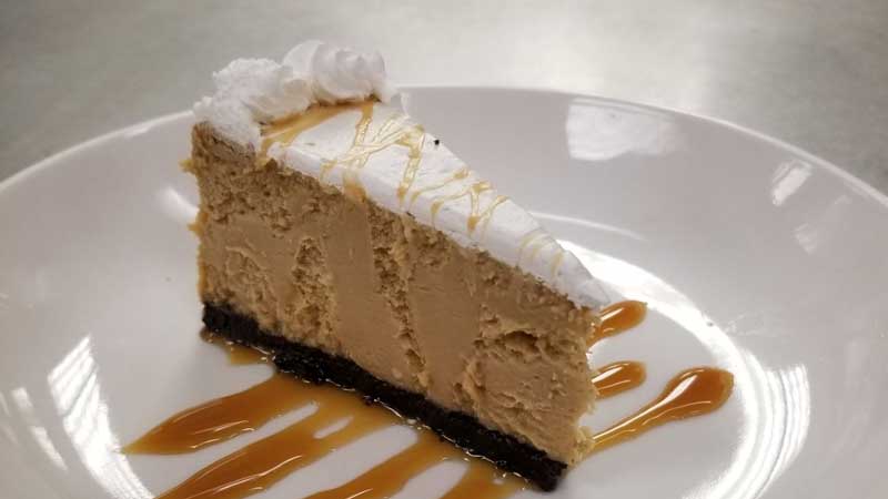 a carrot cake on a plate with a caramel drizzle